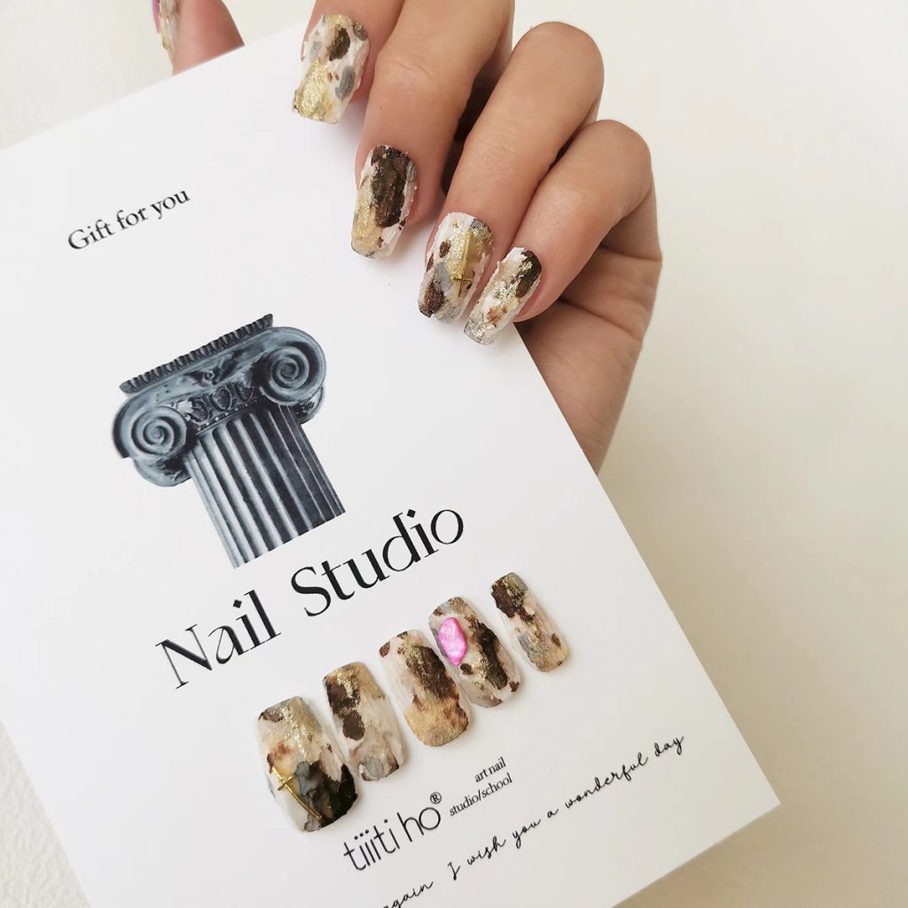 Artistic press-on nails with a gold and brown marble design, displayed on a white card from EasyPressOn.com :Tiiti Ho Nail Studio.