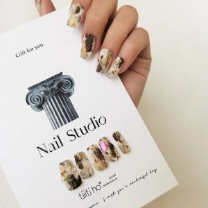Artistic press-on nails with a gold and brown marble design, displayed on a white card from EasyPressOn.com :Tiiti Ho Nail Studio.