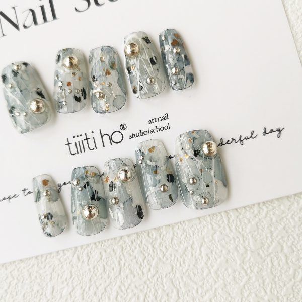 Artistic press-on nails with a silver and grey design, featuring metallic accents, displayed on a white card from EasyPressOn.com : Tiiti Ho Nail Studio.