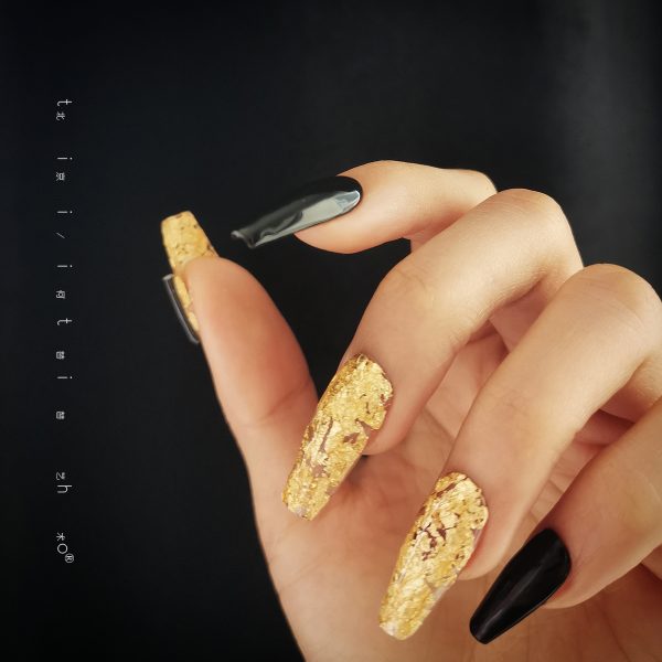Luxurious press-on nails with a black and gold foil design, displayed on a card from EasyPressOn.com : Tiiti Ho Nail Studio.