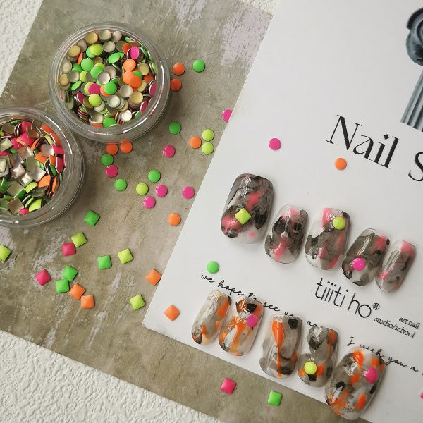 Colorful press-on nails with vibrant designs, featuring pink, orange, and neon green accents, displayed on a card from EasyPressOn.com : Tiiti Ho Nail Studio.