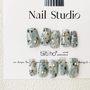 Artistic press-on nails with a silver and grey design, featuring metallic accents, displayed on a white card from EasyPressOn.com : Tiiti Ho Nail Studio.