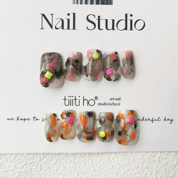 Colorful press-on nails with vibrant designs, featuring pink, orange, and neon green accents, displayed on a card from EasyPressOn.com : Tiiti Ho Nail Studio.