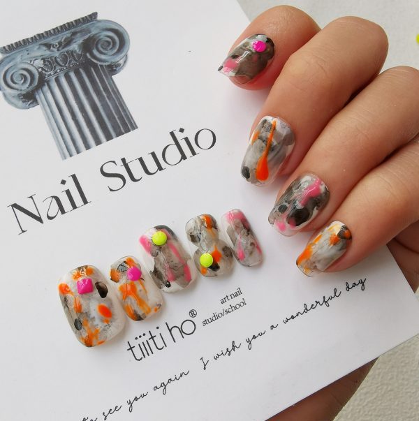 Colorful press-on nails with vibrant designs, featuring pink, orange, and neon green accents, displayed on a card from EasyPressOn.com : Tiiti Ho Nail Studio.