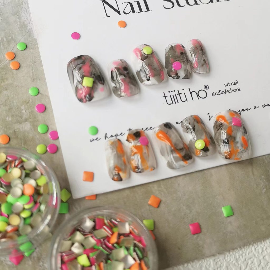Colorful press-on nails with vibrant designs, featuring pink, orange, and neon green accents, displayed on a card from EasyPressOn.com : Tiiti Ho Nail Studio.