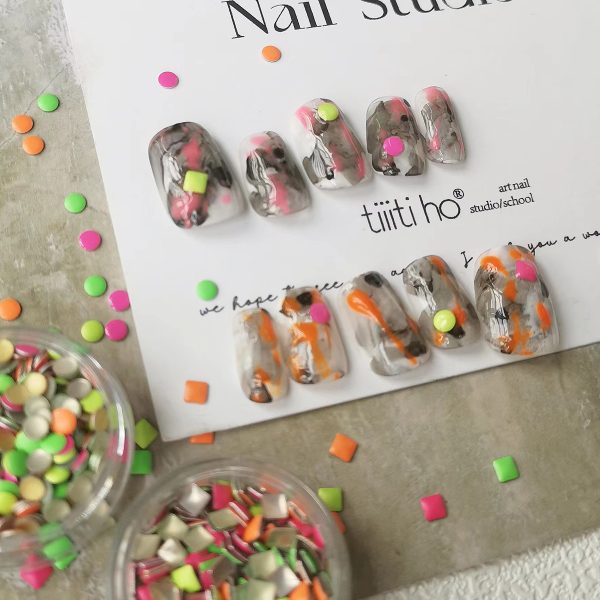 Colorful press-on nails with vibrant designs, featuring pink, orange, and neon green accents, displayed on a card from EasyPressOn.com : Tiiti Ho Nail Studio.