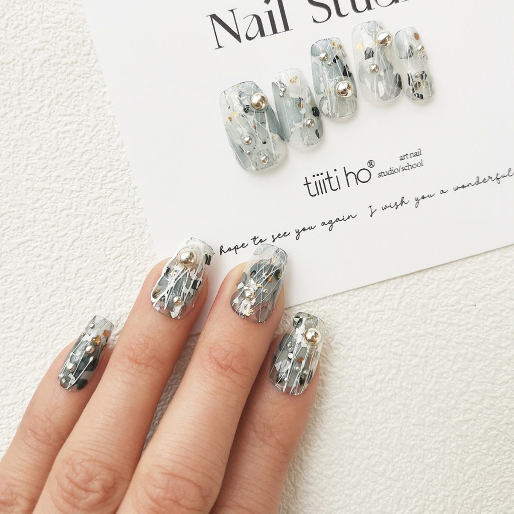 Artistic press-on nails with a silver and grey design, featuring metallic accents, displayed on a white card from EasyPressOn.com : Tiiti Ho Nail Studio.