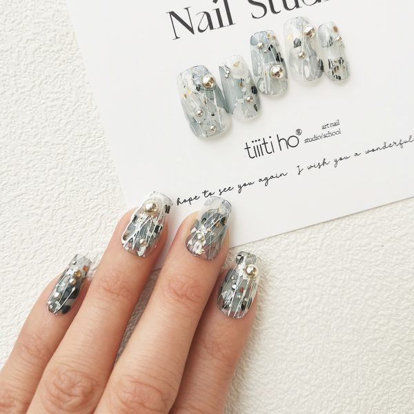 Artistic press-on nails with a silver and grey design, featuring metallic accents, displayed on a white card from EasyPressOn.com : Tiiti Ho Nail Studio.