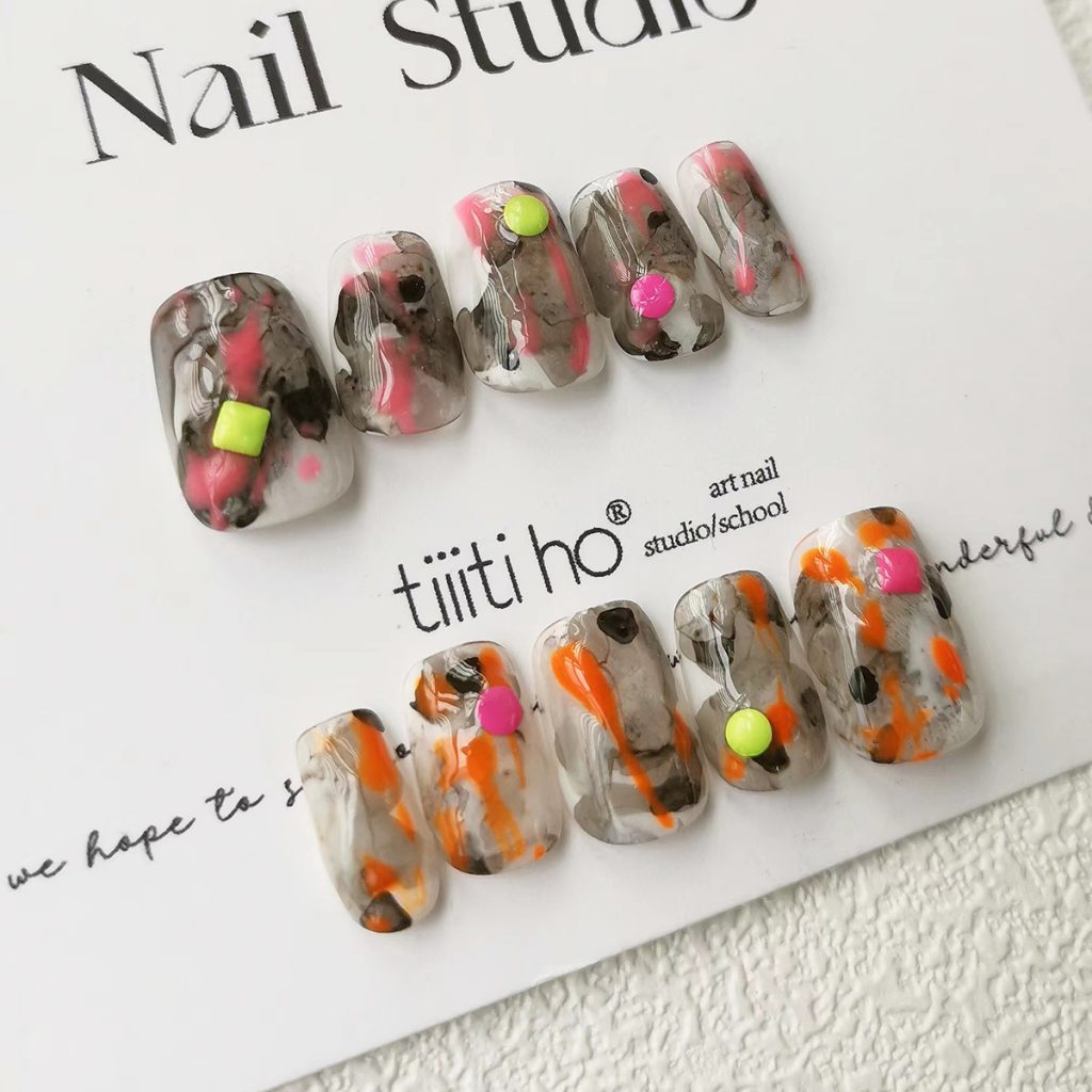 Colorful press-on nails with vibrant designs, featuring pink, orange, and neon green accents, displayed on a card from EasyPressOn.com : Tiiti Ho Nail Studio.