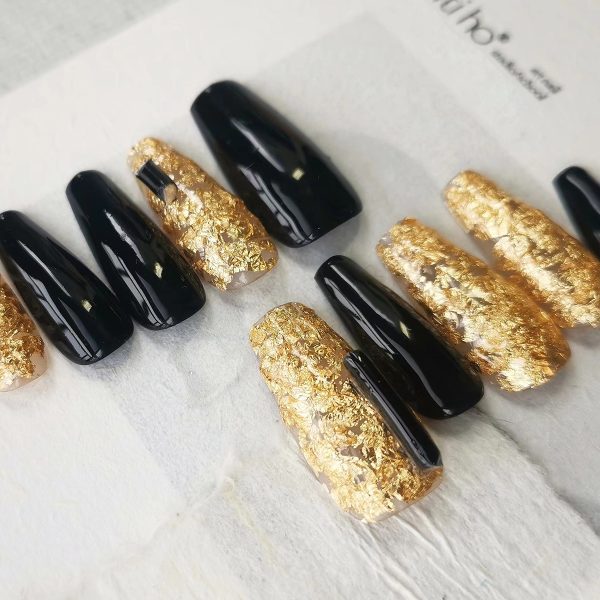Luxurious press-on nails with a black and gold foil design, displayed on a card from EasyPressOn.com : Tiiti Ho Nail Studio.